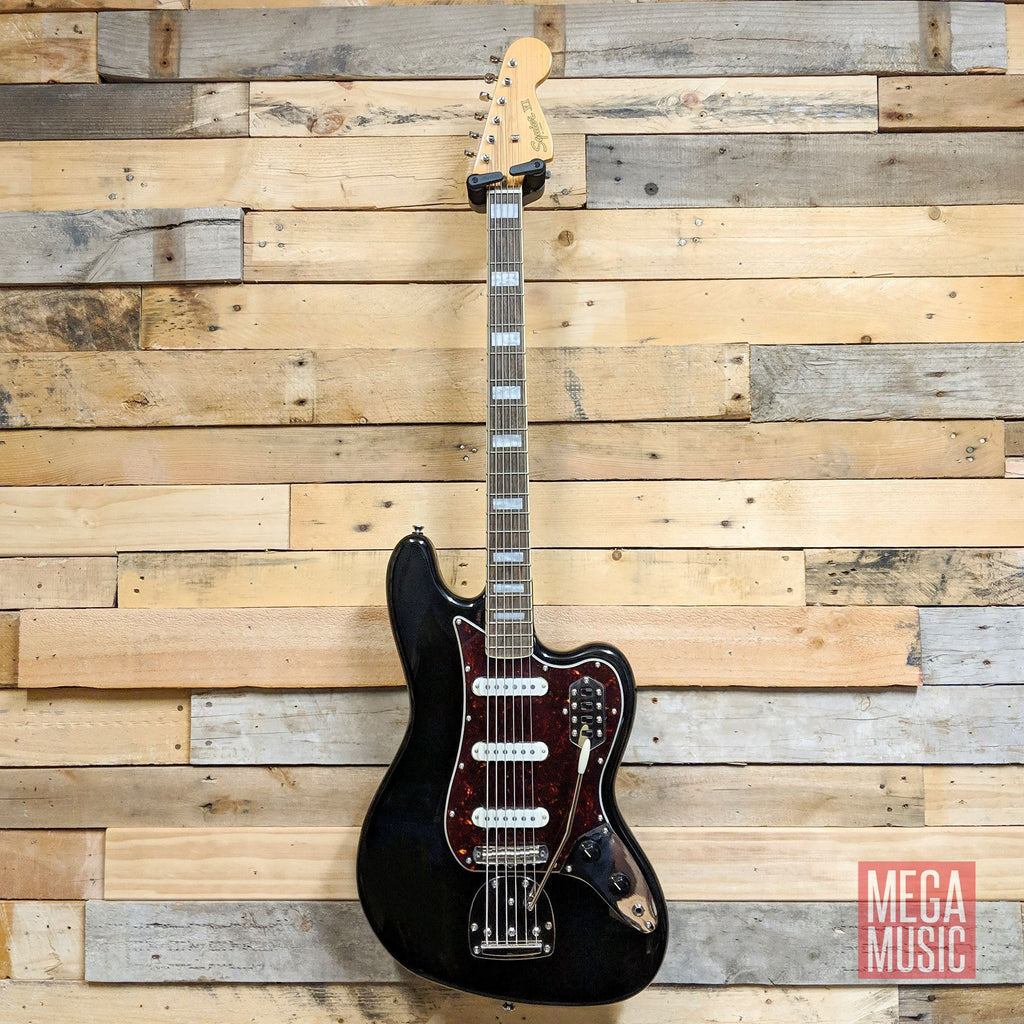 Squier Classic Vibe Bass VI guitar with black body and laurel fretboard, six-string electric bass guitar on a white background.