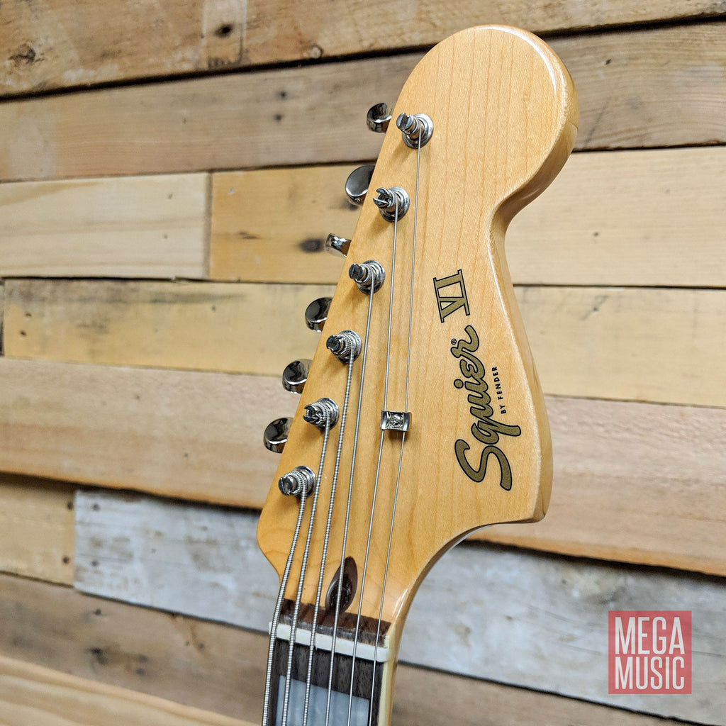 Squier Classic Vibe Bass VI guitar with black body and laurel fretboard, showing the instrument's neck and headstock.