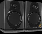 Behringer Media 40USB 4-inch studio monitor speakers pair, showing black speakers with control knobs and cables for professional audio.