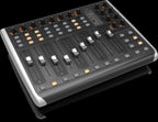 Behringer X-Touch Compact USB controller keyboard with knobs and buttons for music production and digital audio control.