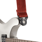 D'Addario Auto Lock Guitar Strap in blood red with black accents, adjustable leather ends, and metal locking mechanism for secure guitar support.