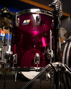 Ludwig Vistalite 3-piece purple drum kit with bass drum, toms, and snare drums, set up on a stage.