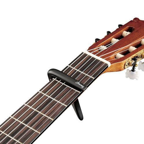 Ibanez ICC10 classical guitar capo in matte black, shown clamped on a guitar neck, designed for easy tuning and secure hold.