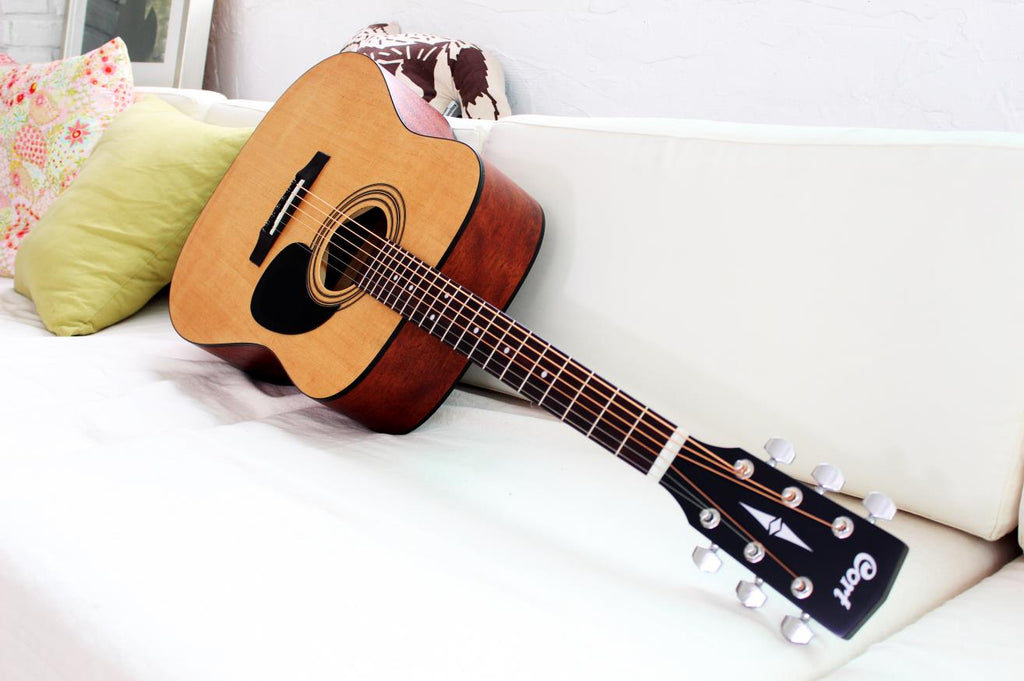 Cort AD810 OP dreadnought acoustic guitar with open pore finish, showcasing its wooden body and fretboard.
