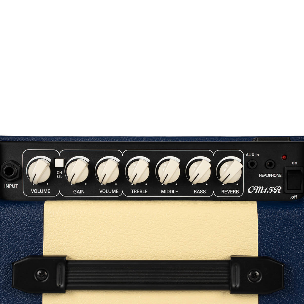 Dark blue Cort CM15R PG 15W guitar combo amplifier with control knobs and speaker grille, compact and portable for practice sessions.