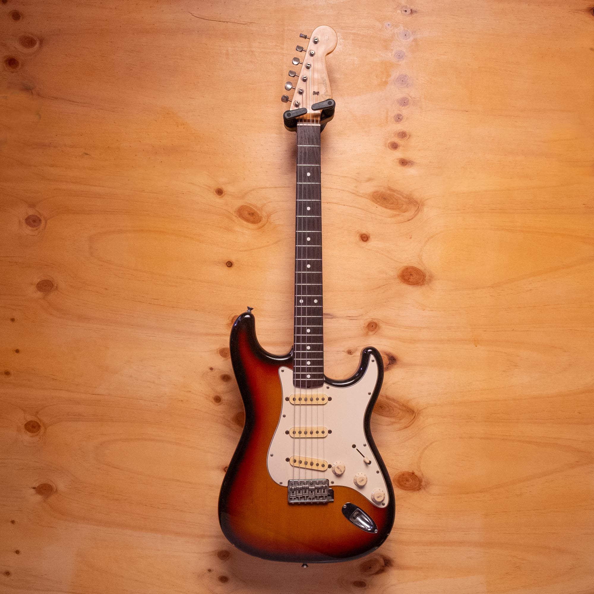 Fender Stratocaster electric guitar made in Japan with sunburst finish and maple neck, positioned on a stand.