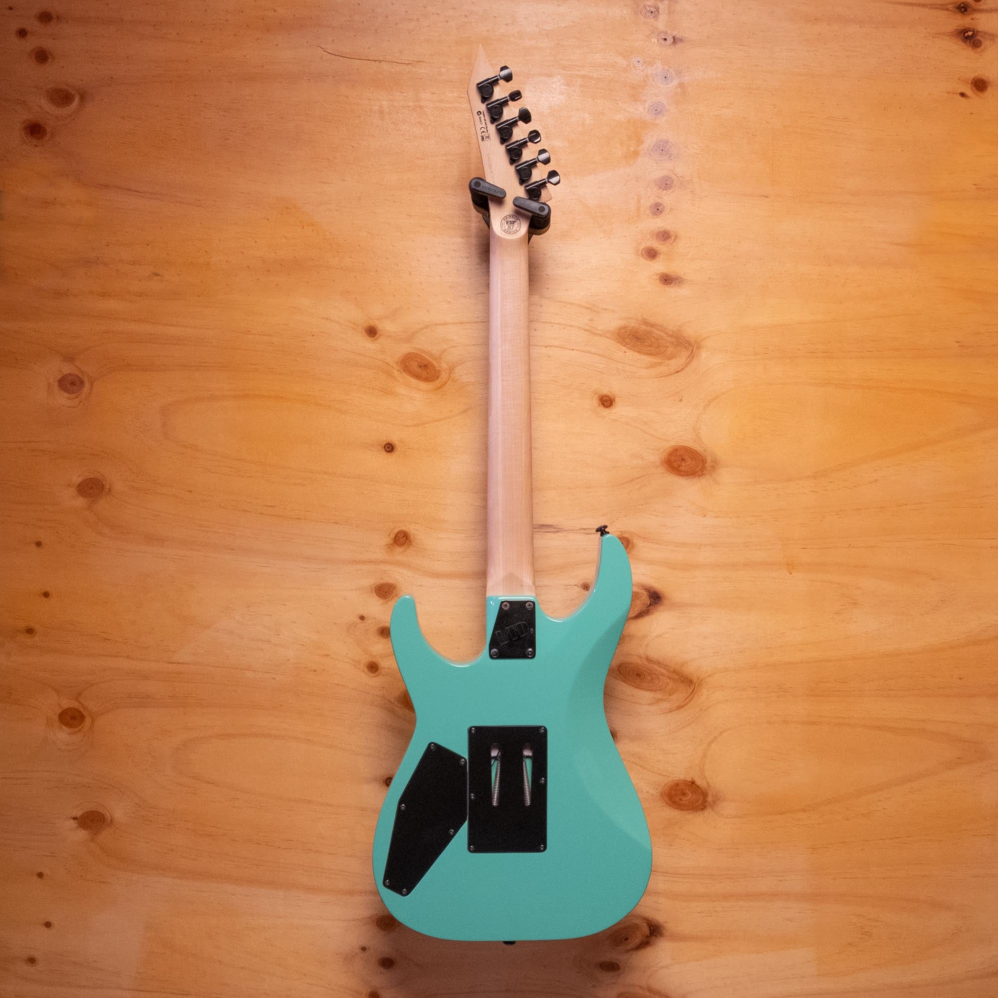 ESP LTD Mirage '87 Series electric guitar with sleek black finish and modern design, shown from the front with detailed hardware.