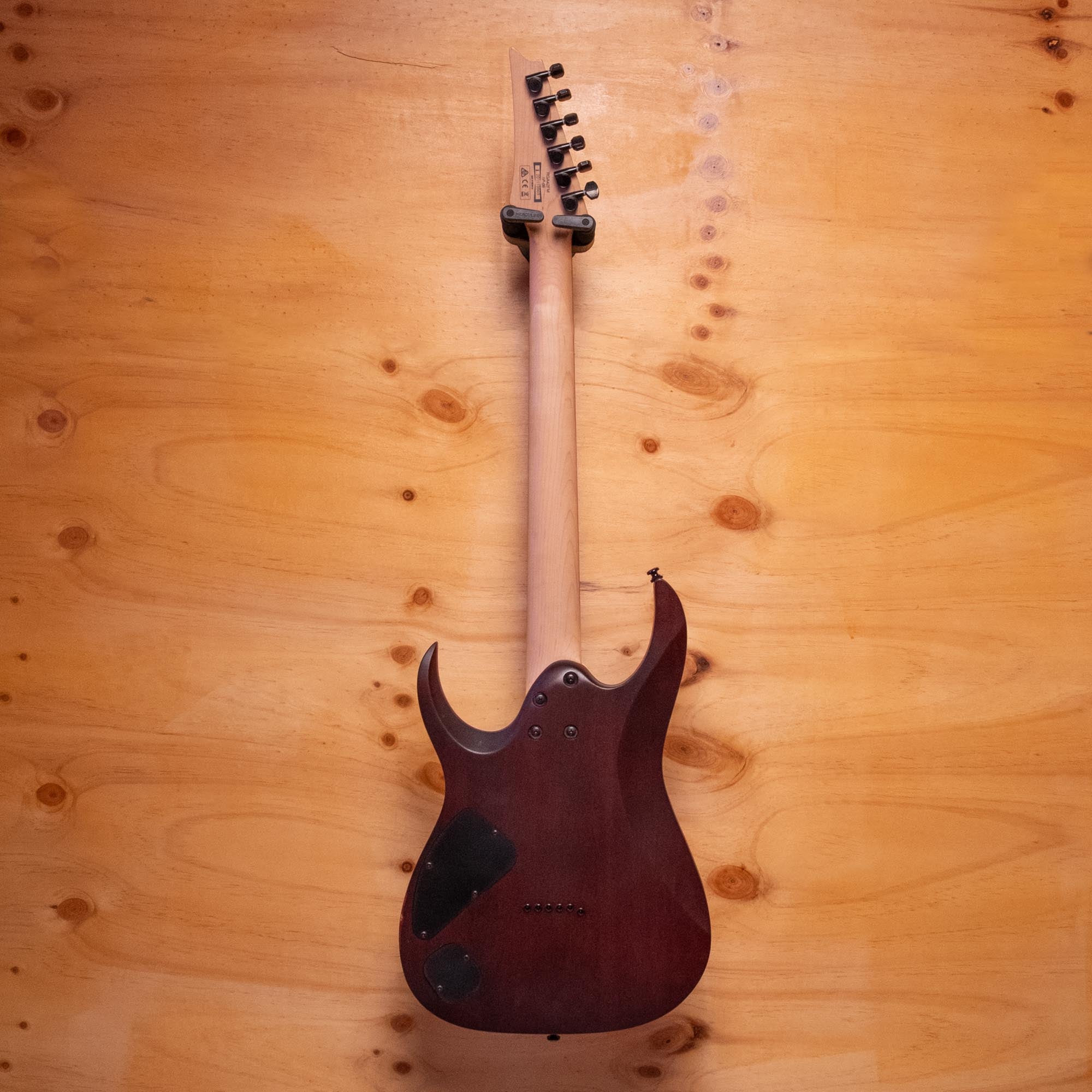 Ibanez RGA42FM electric guitar with a sleek finish, double-cutaway body, and six-string design, resting on a stand.