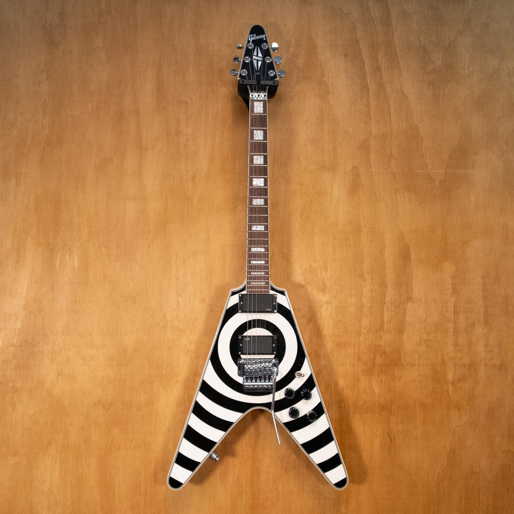 Preowned Gibson Copy Bullseye Flying V electric guitar with bold design, black finish, and distinctive shape, displayed on a stand.