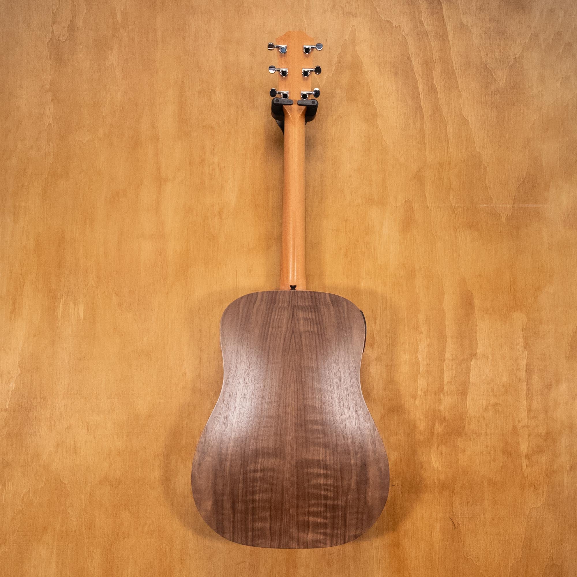 Taylor Big Baby acoustic guitar in walnut finish, showing the body, pickguard, and bridge in a natural, well-lit setting.