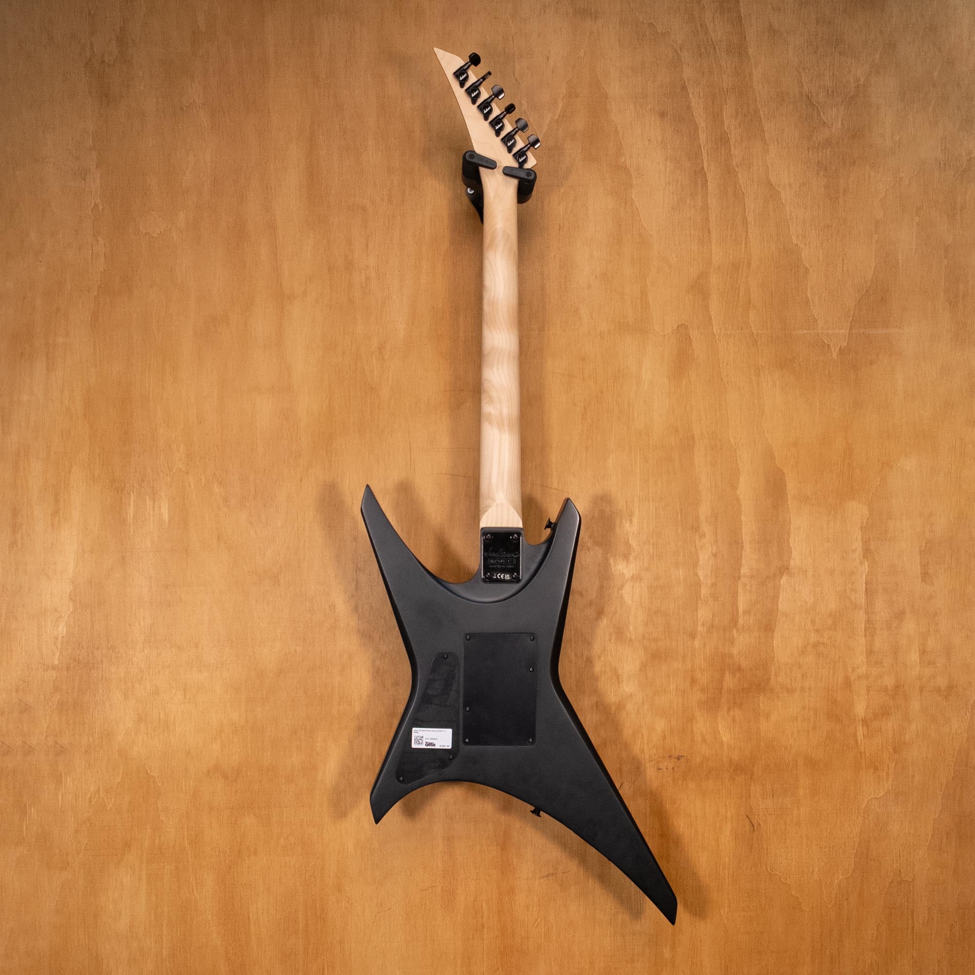 Preloved Jackson JS32 Warrior electric guitar with black body, white pickguard, and maple neck, captured from front angle.