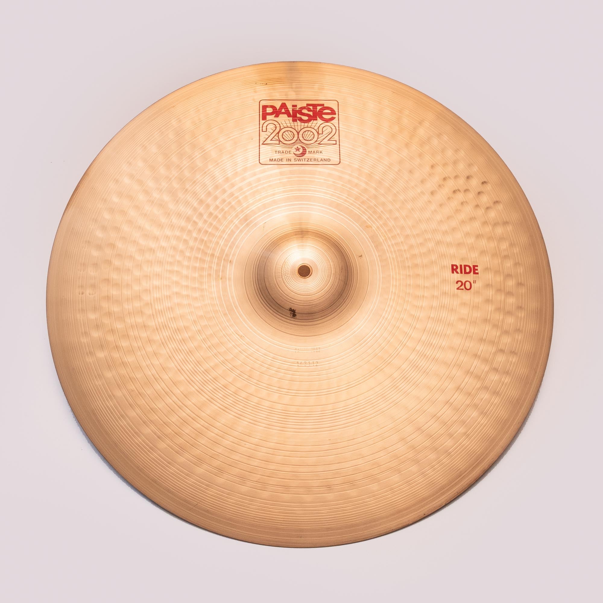 Preloved Paiste 2002 20-inch ride cymbal showing its polished surface and detailed branding, ideal for drum set use.