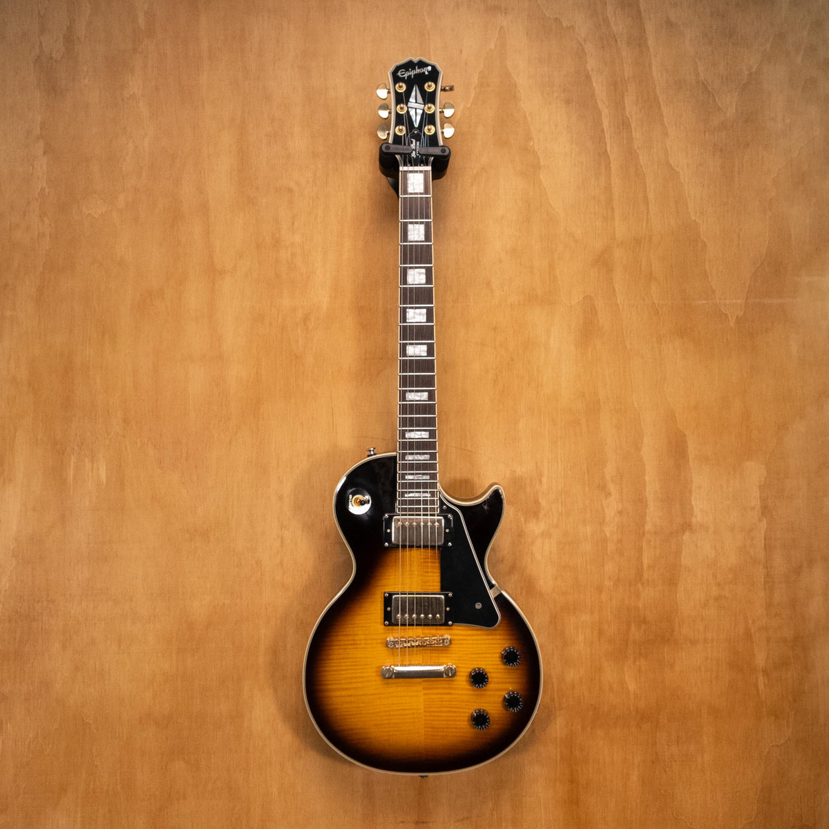 Epiphone Les Paul Custom Plus electric guitar in vintage sunburst finish, showing the body and neck details.