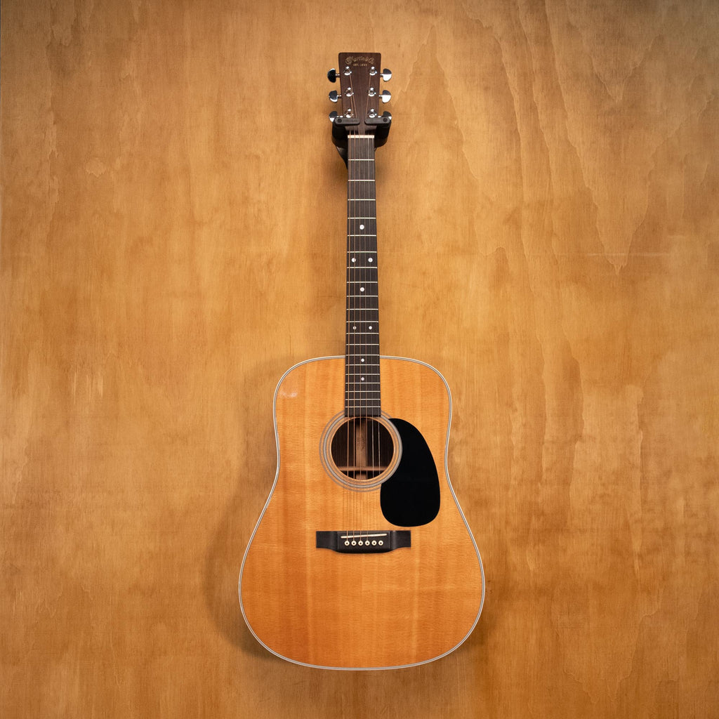 Preloved Martin D-28 dreadnought acoustic guitar with rich wood finish and six steel strings, shown in a close-up shot.