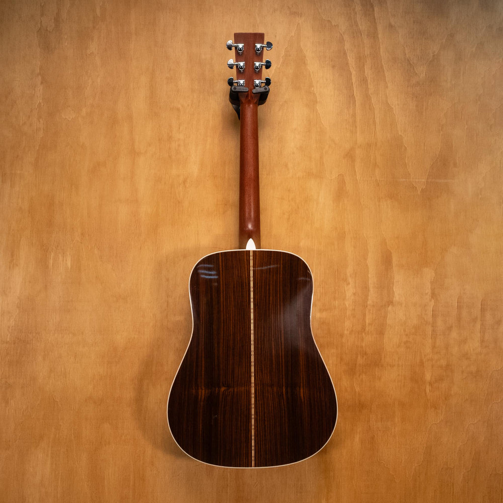 Martin D-28 dreadnought acoustic guitar with rich wood finish and six strings, shown from a side angle.