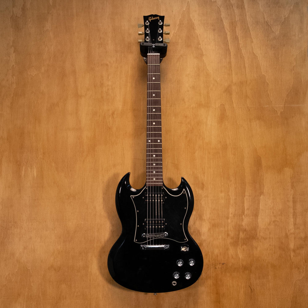 Preloved Gibson SG Standard Ebony electric guitar with double-cutaway body and humbucker pickups, shown in a close-up shot.