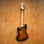 Squier Affinity Jazz Bass guitar in sunburst finish with maple neck and black pickguard, displayed on a stand.
