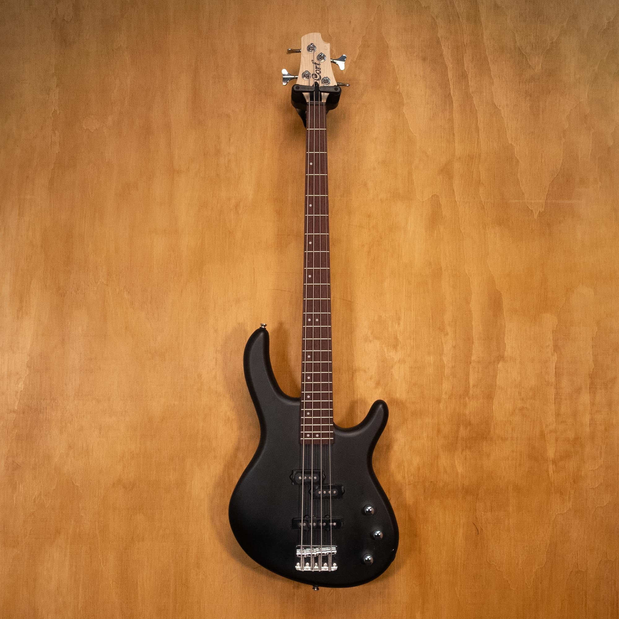 Black Cort Action PJ Bass Guitar with double cutaway body and four strings, shown from a front angle.
