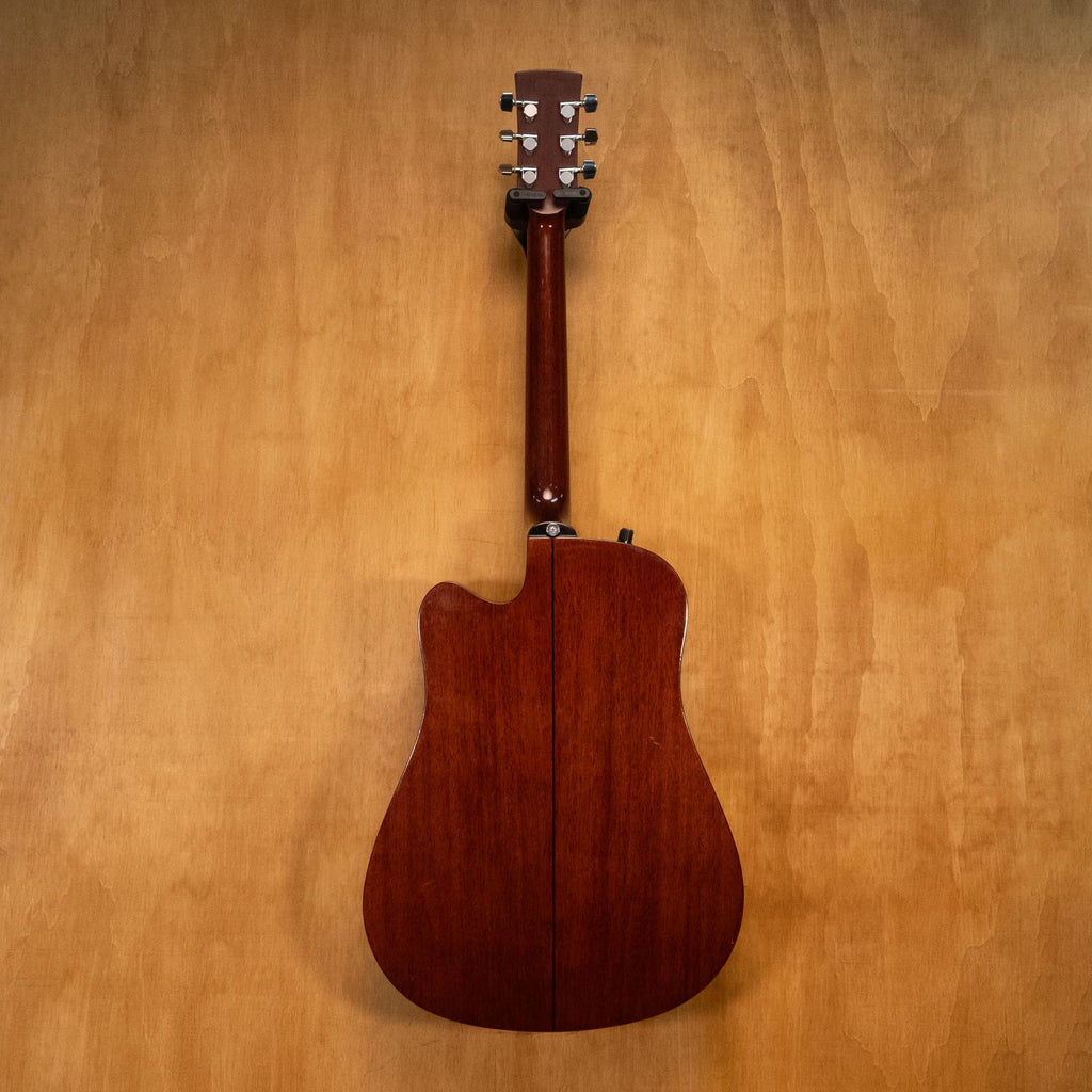 Ibanez PF10CE acoustic guitar with a natural wood finish, cutaway body, and steel strings, displayed on a stand.