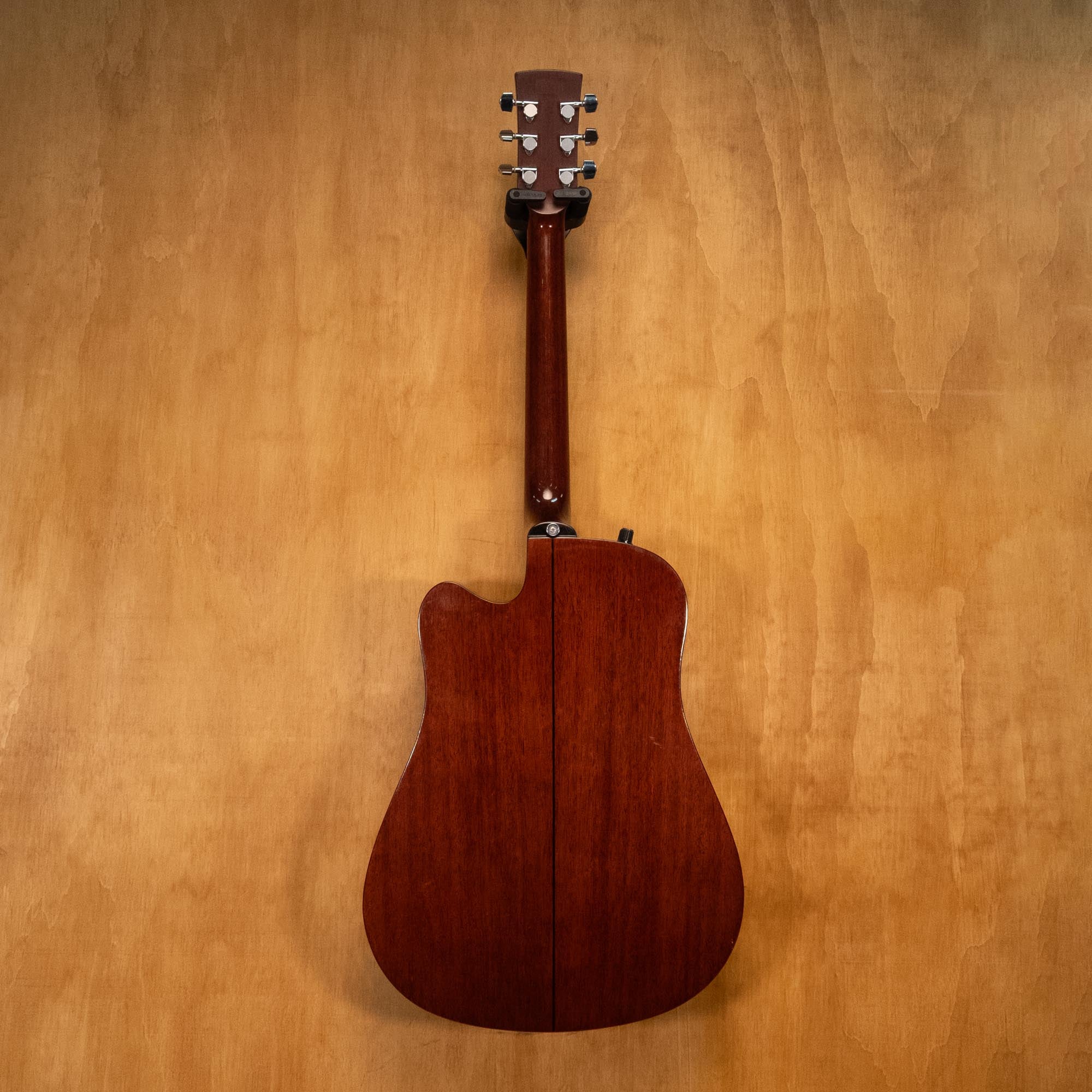 Ibanez PF10CE acoustic guitar with a natural wood finish, cutaway body, and steel strings, displayed on a stand.