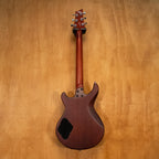 Cort M200 electric guitar with a black body, chrome hardware, and a maple neck, shown resting on a stand.