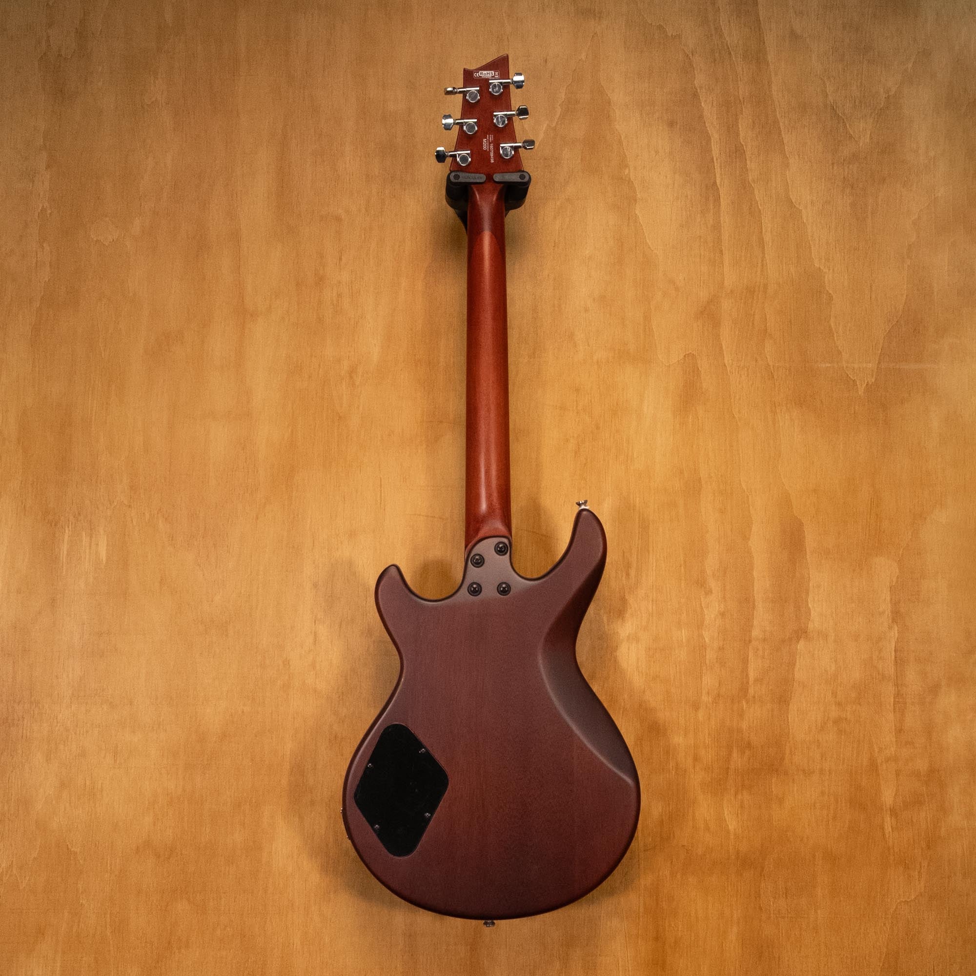 Cort M200 electric guitar with a black body, chrome hardware, and a maple neck, shown resting on a stand.