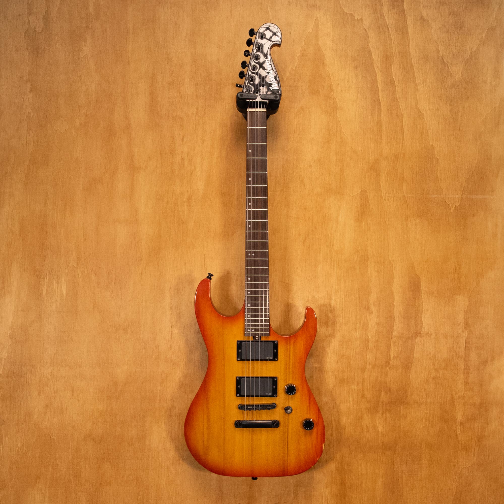 Washburn X200PROE electric guitar with a sunburst finish, solid body, and six-string design, shown on a stand.