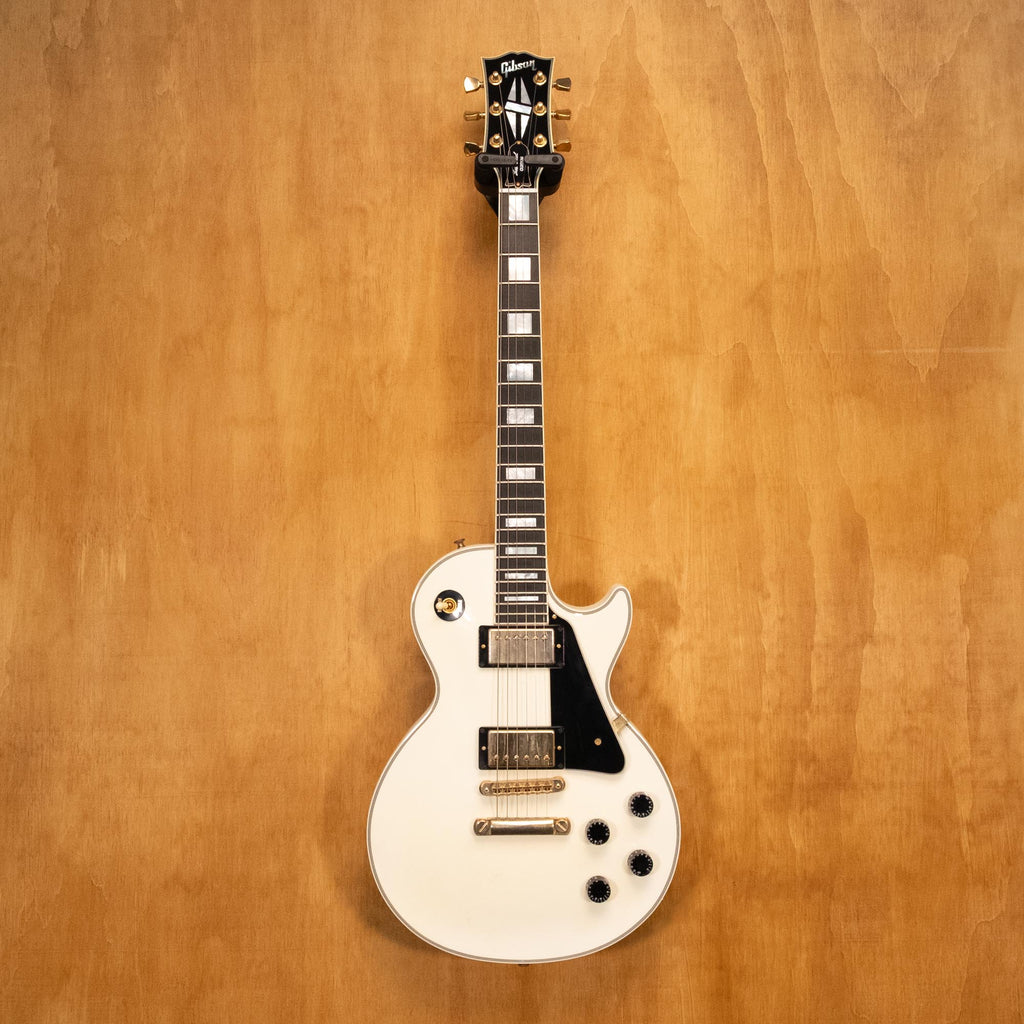 Gibson Les Paul Custom electric guitar in Alpine White with gold hardware, showcasing the body, neck, and pickups.
