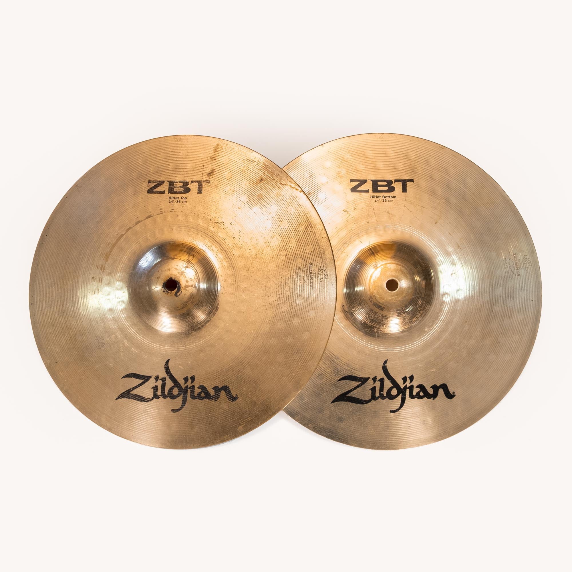 Preloved Zildjian ZBT 14-inch hi-hat cymbals, pair of single cymbals for drum set, with visible branding and wear.