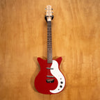 Red Danelectro Stock '59 electric guitar with double-cutaway body and vintage-style pickups, placed on a stand.