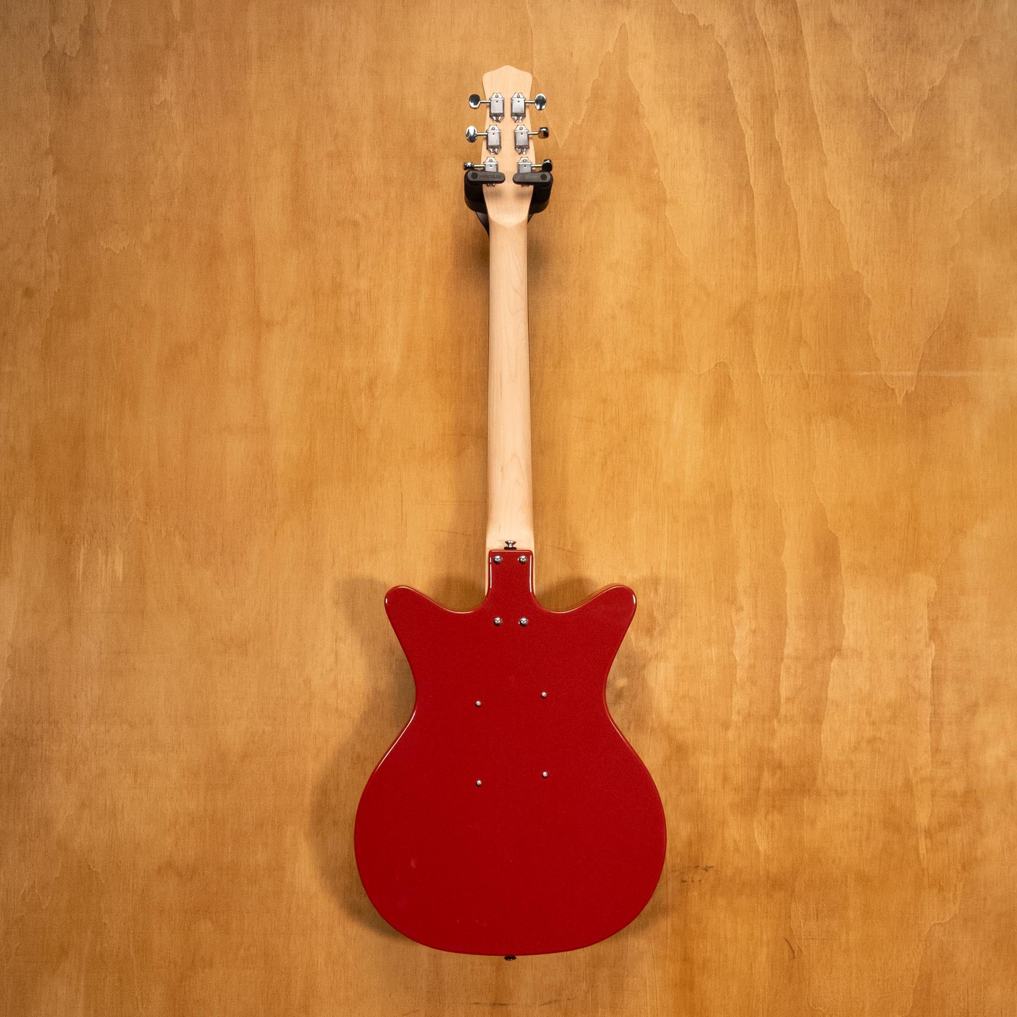 Danelectro Stock '59 electric guitar in red with vintage-style body and chrome hardware, shown in a close-up view.