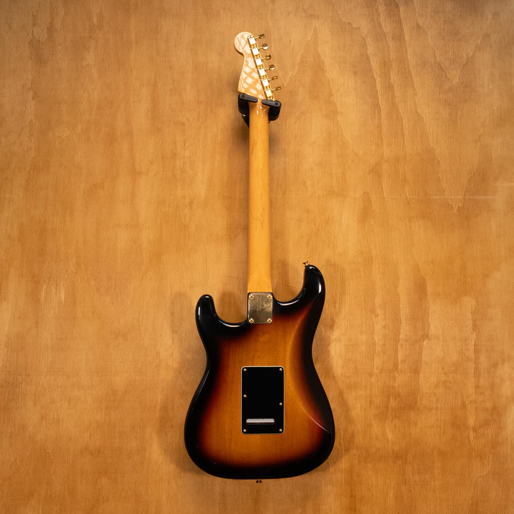 Fender SRV Stratocaster '04 electric guitar with sunburst finish, maple neck, and three pickups, showcased on a stand.