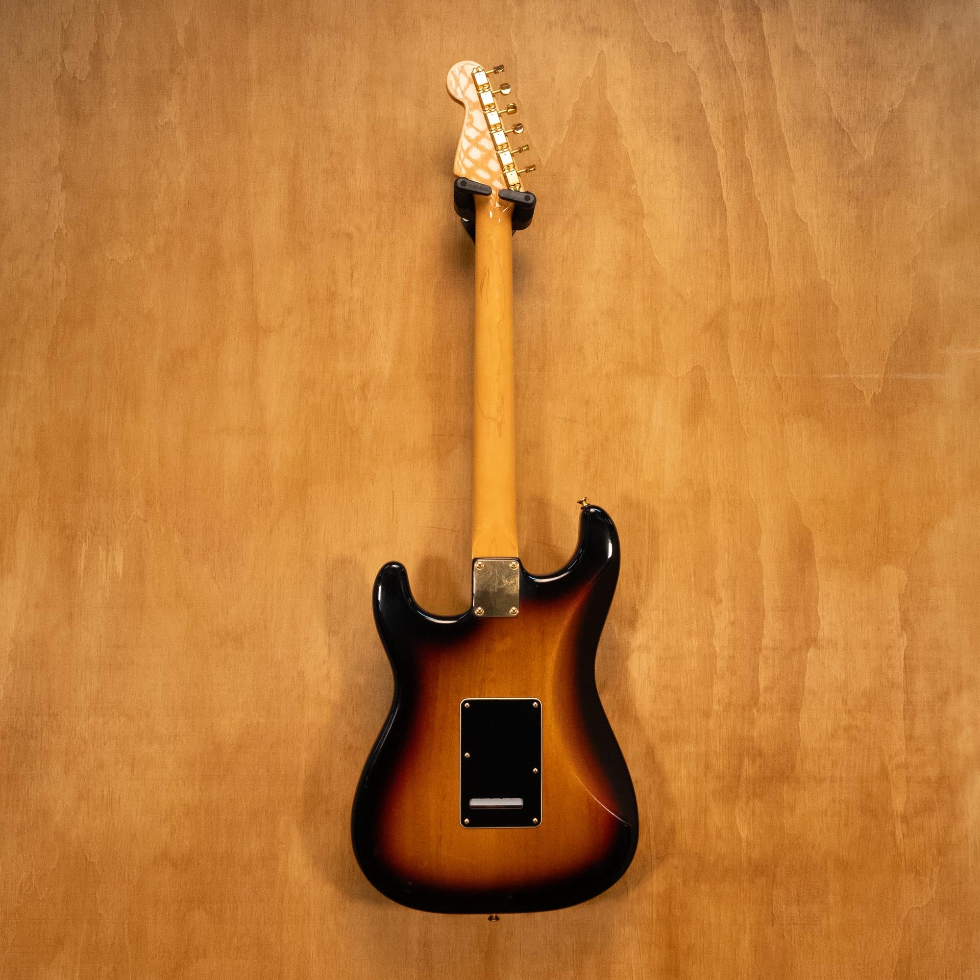 Fender SRV Stratocaster '04 electric guitar with sunburst finish, maple neck, and three pickups, showcased on a stand.