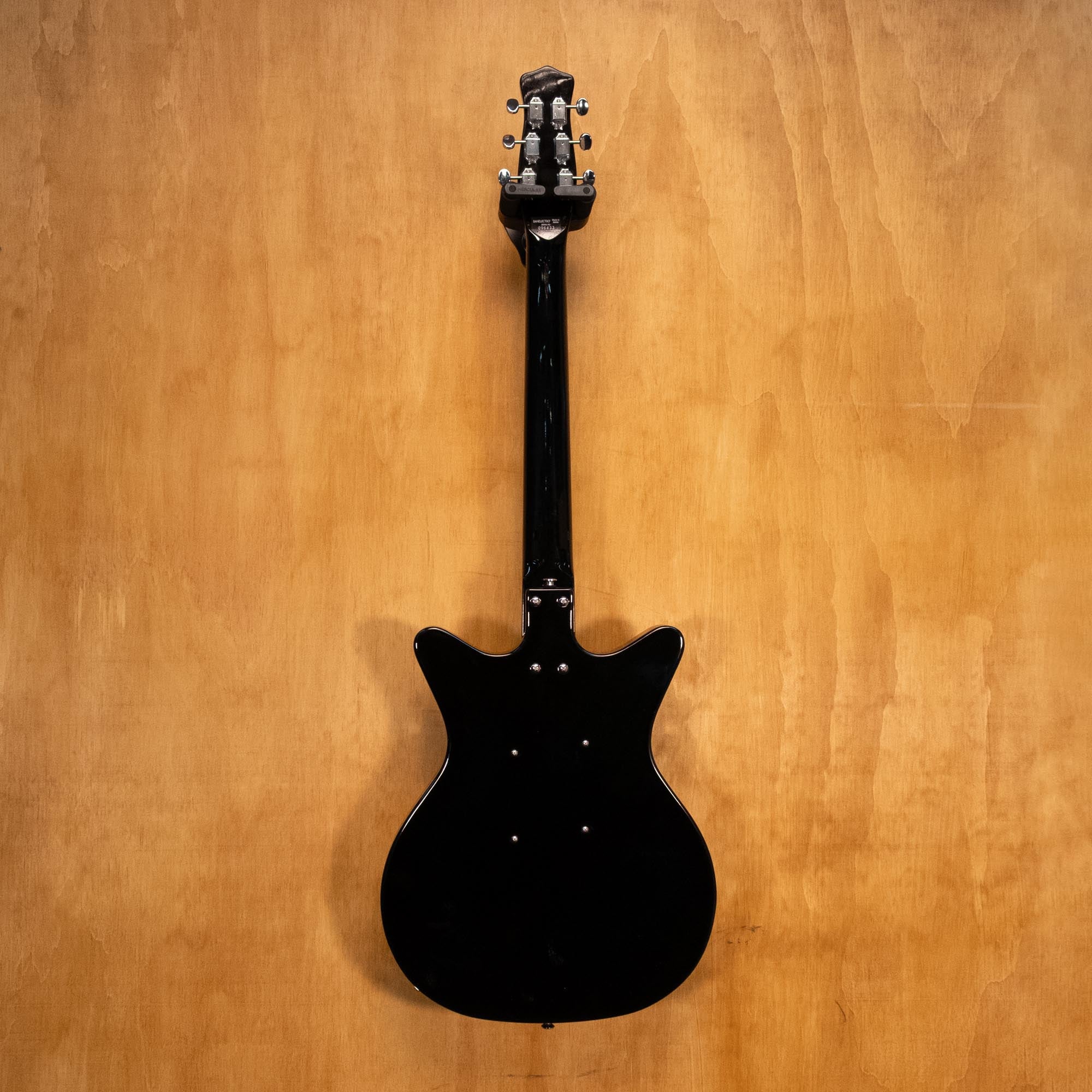 Danelectro '59M NOS electric guitar in black with a vintage-style body and chrome hardware, shown from a front angle.