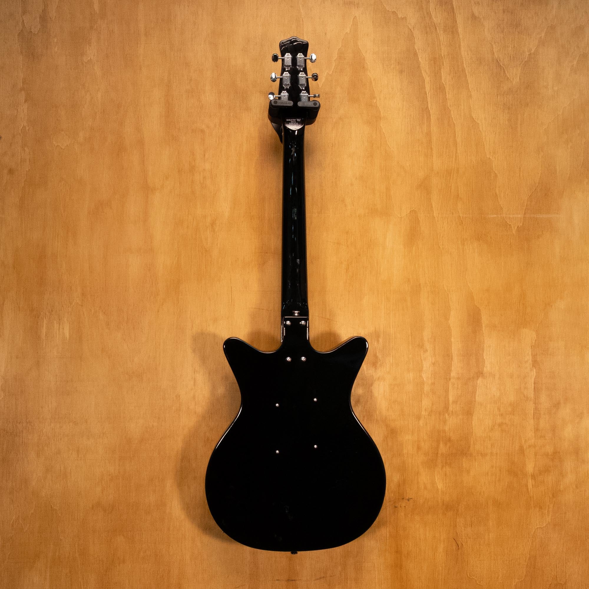 Danelectro '59M NOS electric guitar in black with vintage-style body and chrome hardware, shown on a plain background.