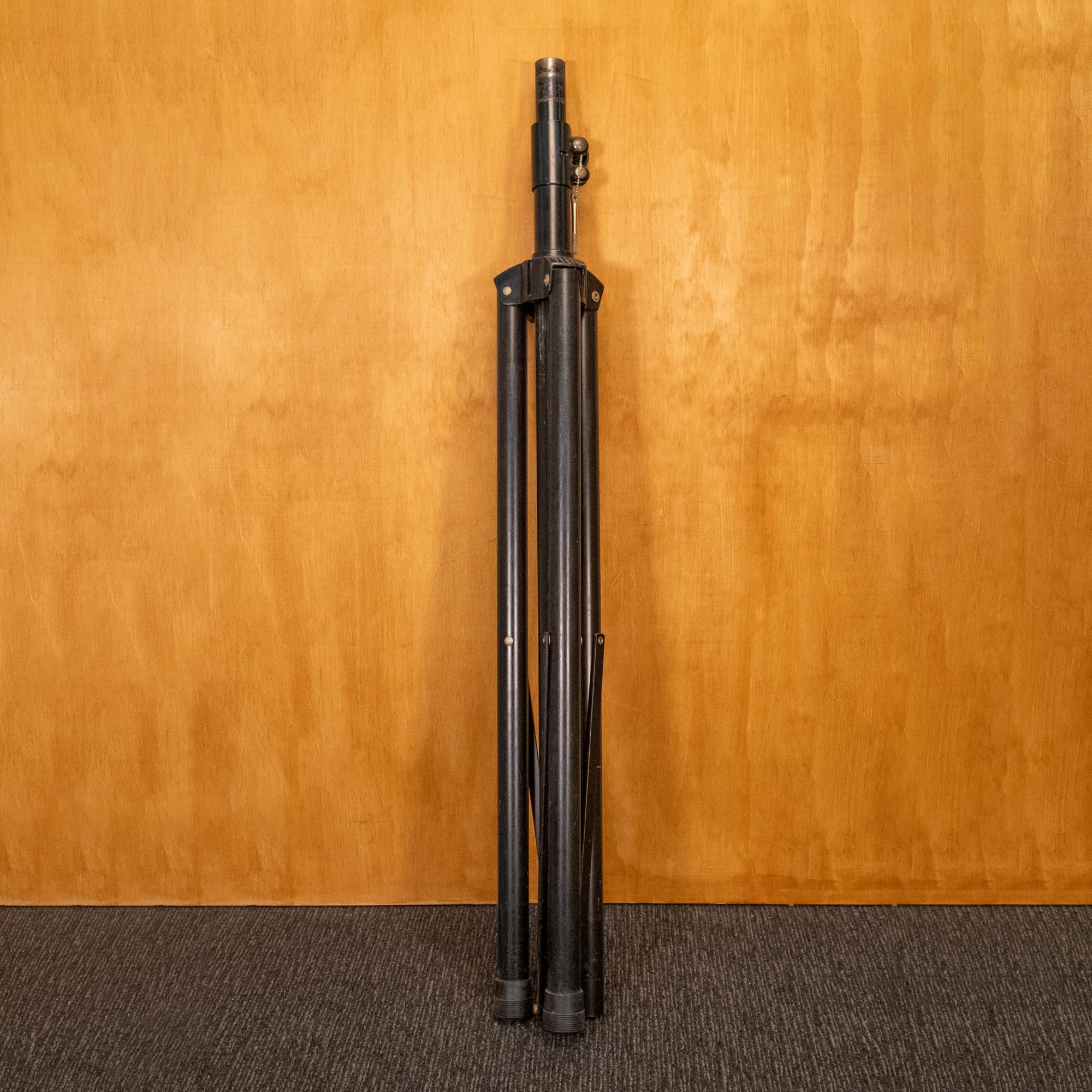 Black speaker stand with adjustable brackets, designed to securely hold audio speakers for optimal sound placement.
