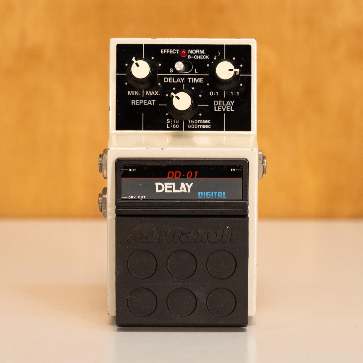 Maxon DD-01 Digital Delay guitar effects pedal showing control knobs and input/output jacks on a pedalboard.