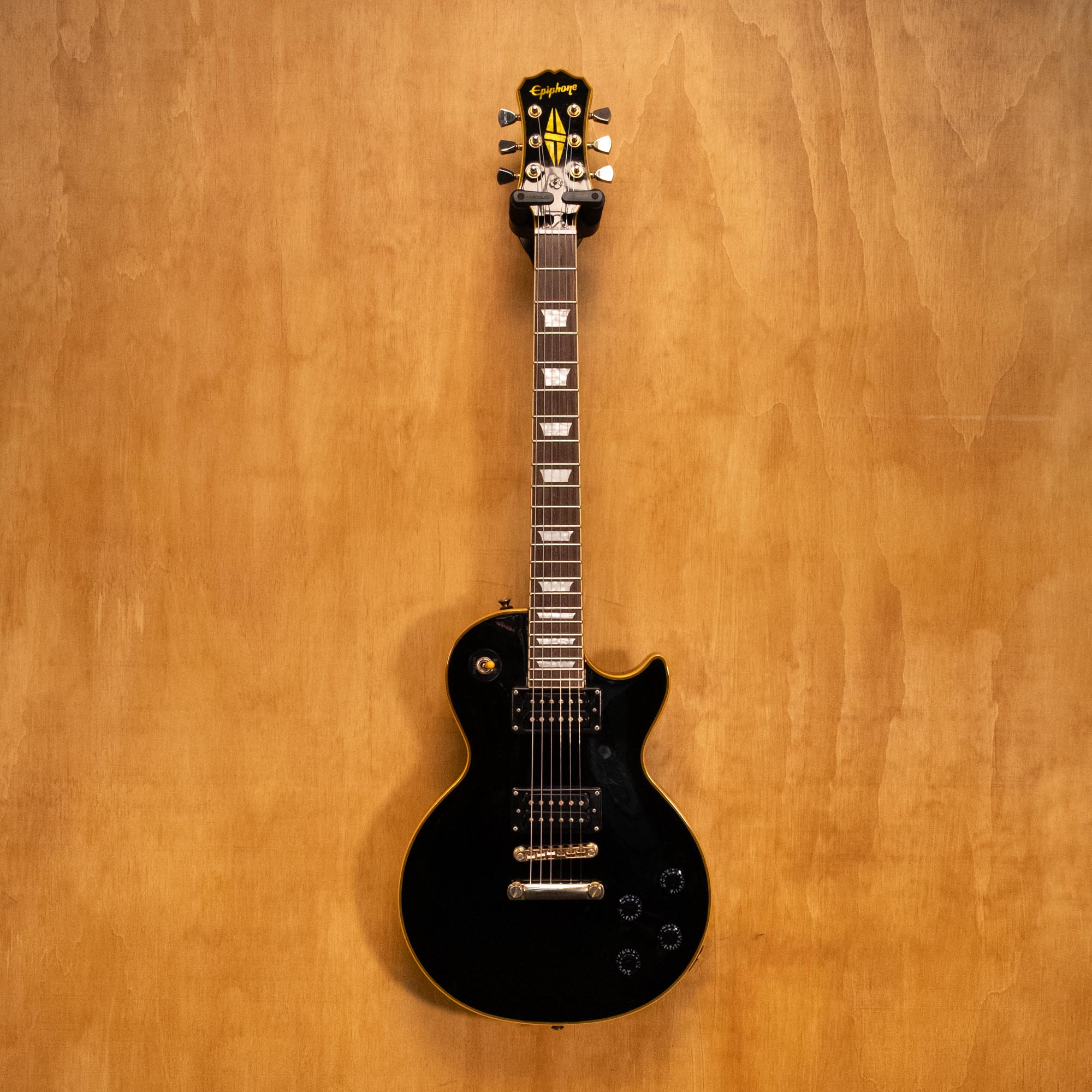 Epiphone LTD Les Paul Custom Classic electric guitar in antique ebony with gold hardware and humbucking pickups, close-up view.