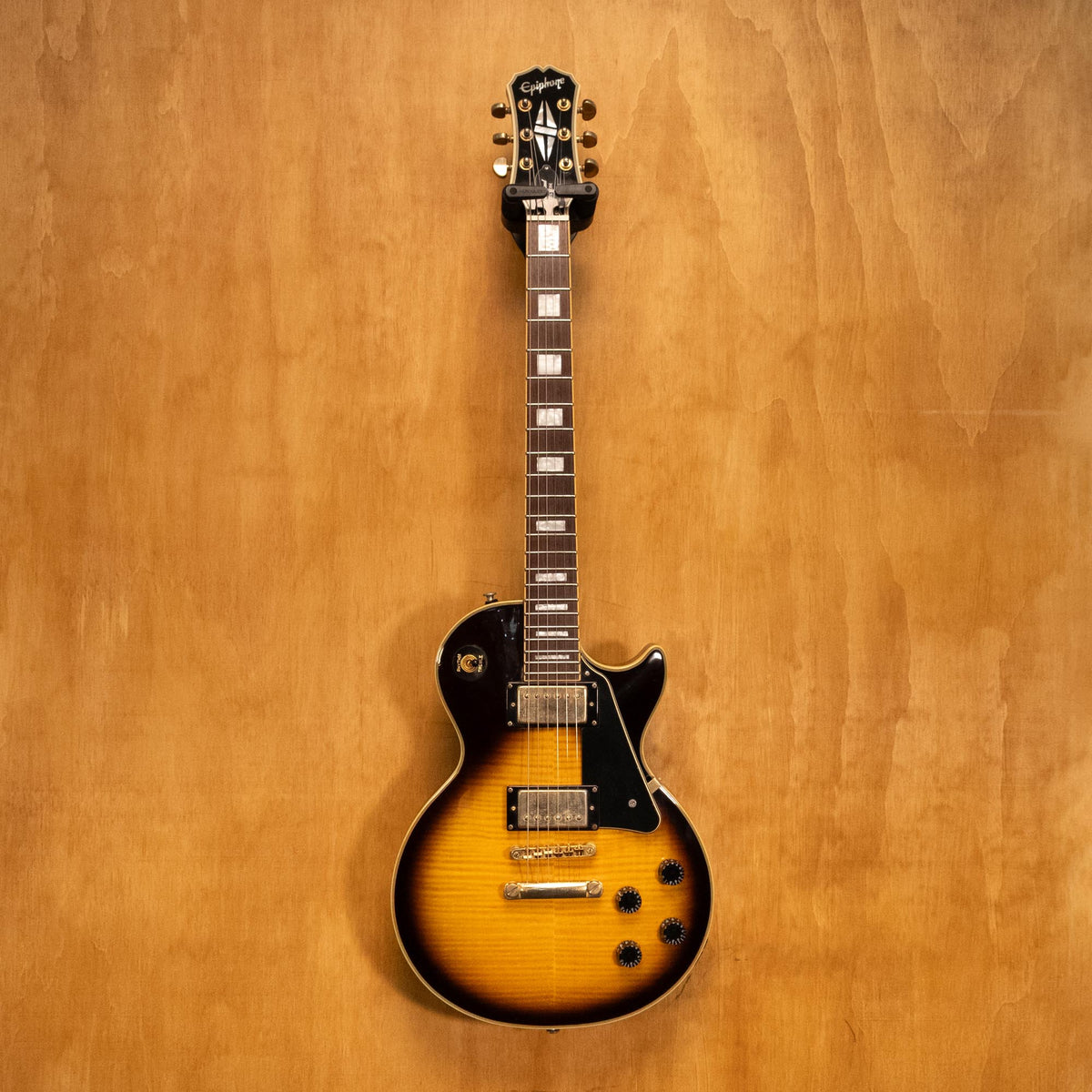 Epiphone Les Paul Custom Plus electric guitar in vintage sunburst finish, shown with body, neck, and pickups in close-up view.
