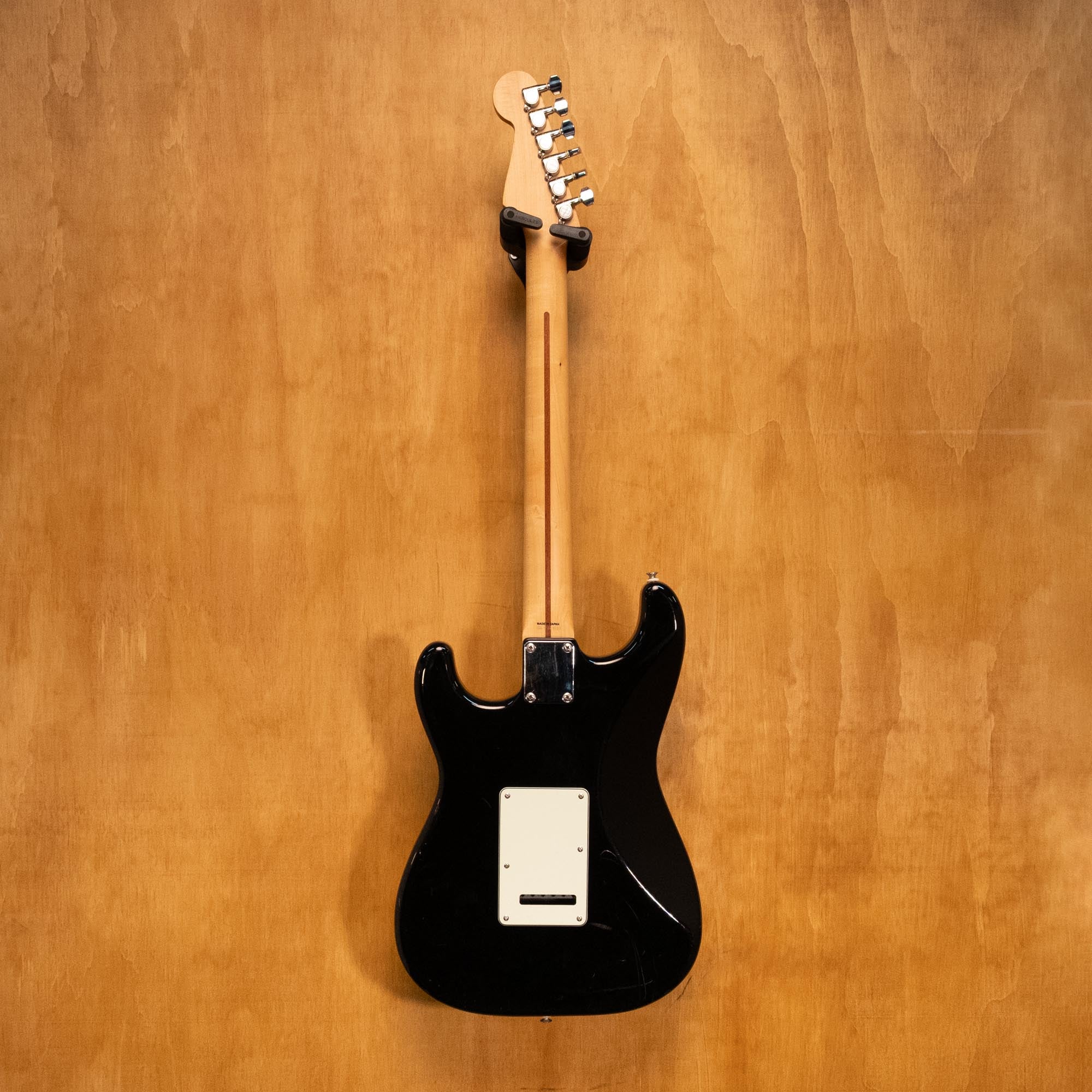 Fender Japan Standard Stratocaster electric guitar in black with white pickguard, six strings, and chrome hardware.