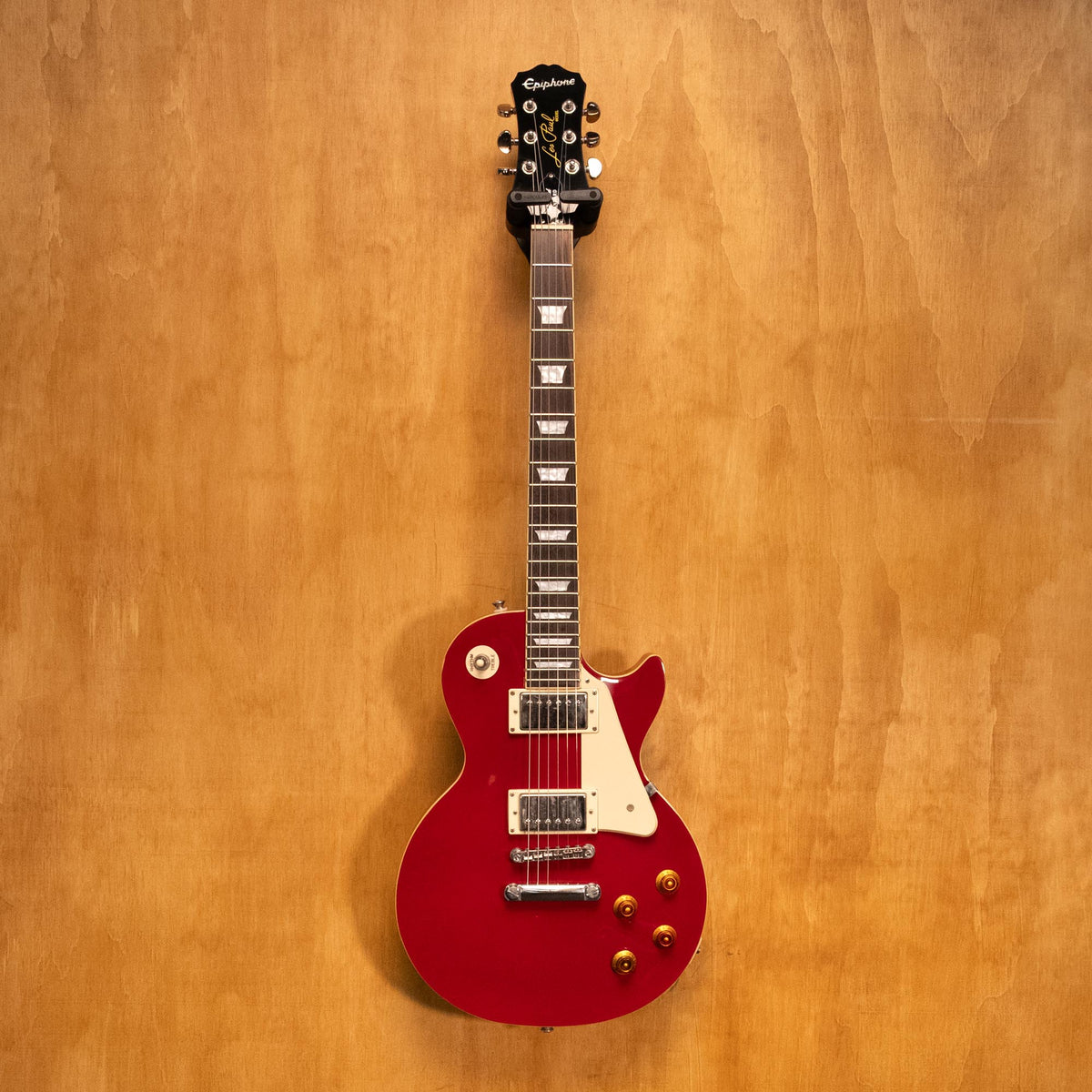 Epiphone Les Paul Standard electric guitar in Cardinal Red with dual humbucker pickups and maple top, close-up view.
