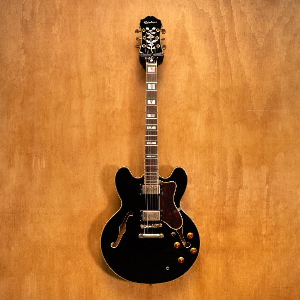 Epiphone Sheraton II electric guitar in ebony finish, showcasing its body, pickguard, and dual humbucker pickups.