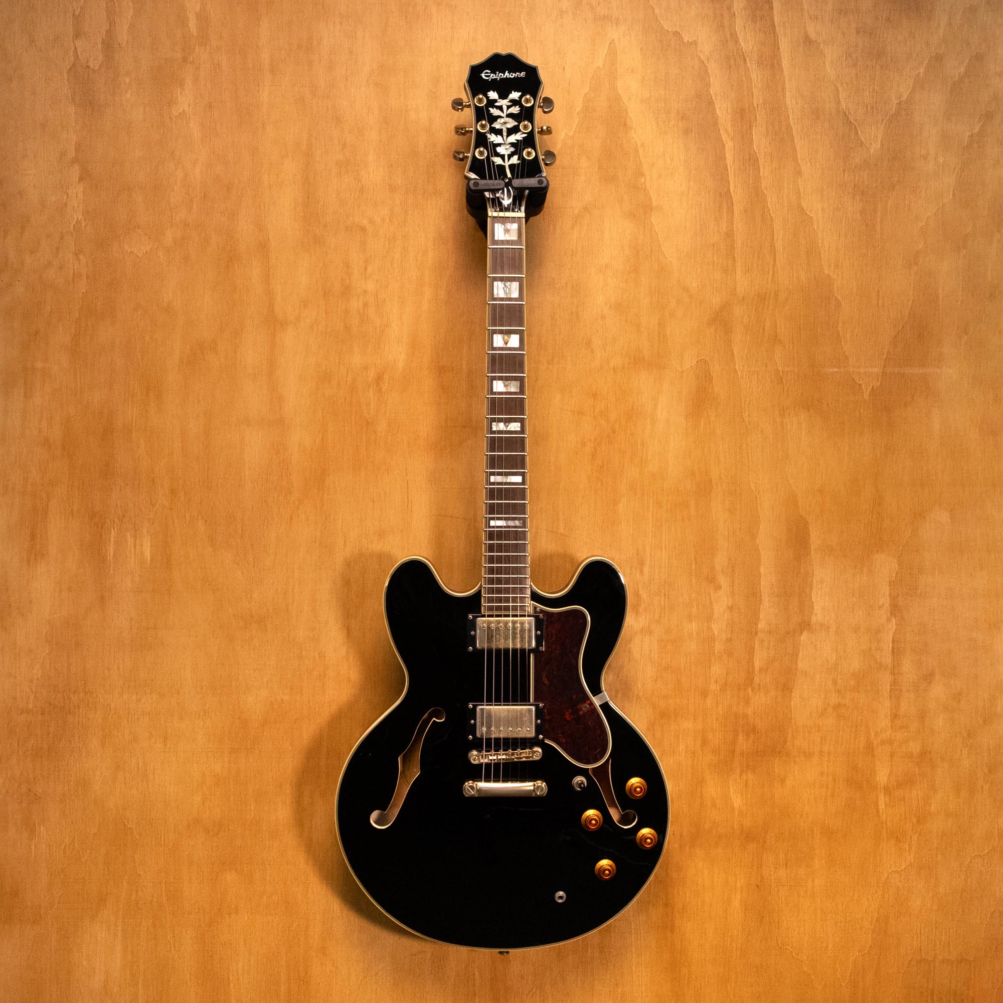 Epiphone Sheraton II electric guitar in ebony finish, showcasing its body, pickguard, and dual humbucker pickups.