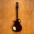 Epiphone 1956 Les Paul Standard Gold Top electric guitar with gold finish and classic design, shown resting on a stand.