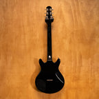 Yamaha SG-RR electric guitar in standard black with double-cutaway design, shown on a stand against a plain background.