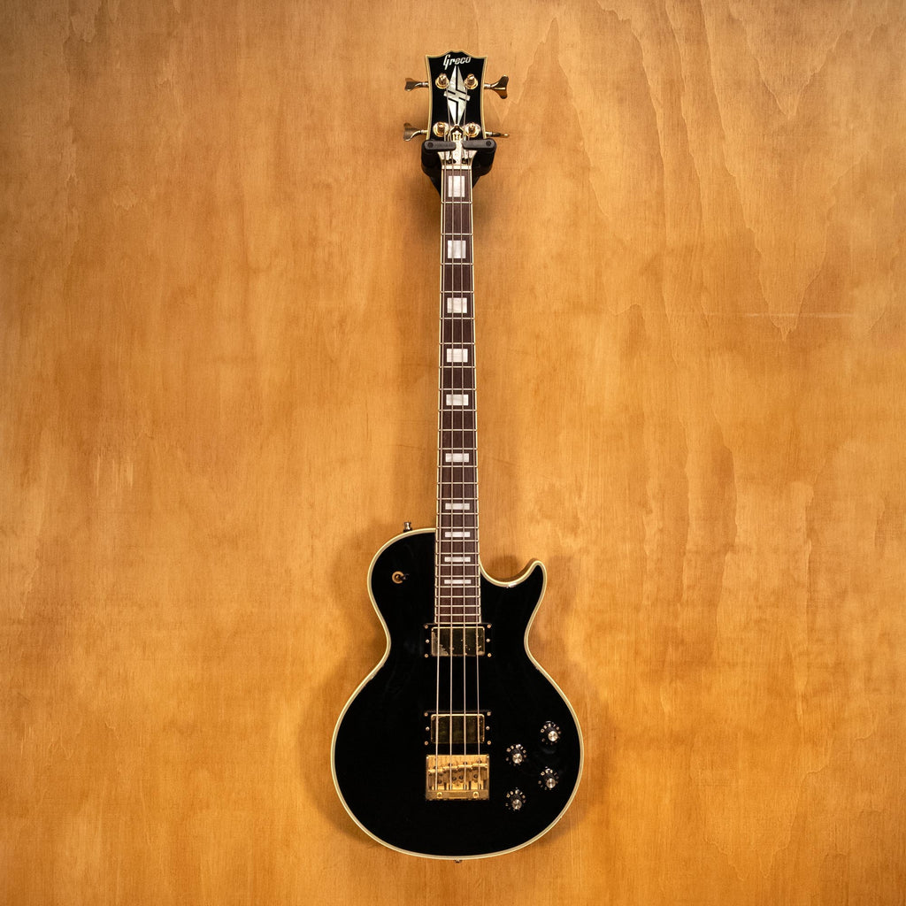 Preloved Greco EGB bass guitar with a sunburst finish, four strings, and classic design, shown on a stand against a plain background.