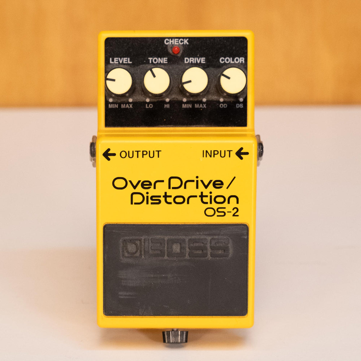 BOSS OS-2 overdrive and distortion guitar effects pedal with control knobs, mounted on a pedalboard.