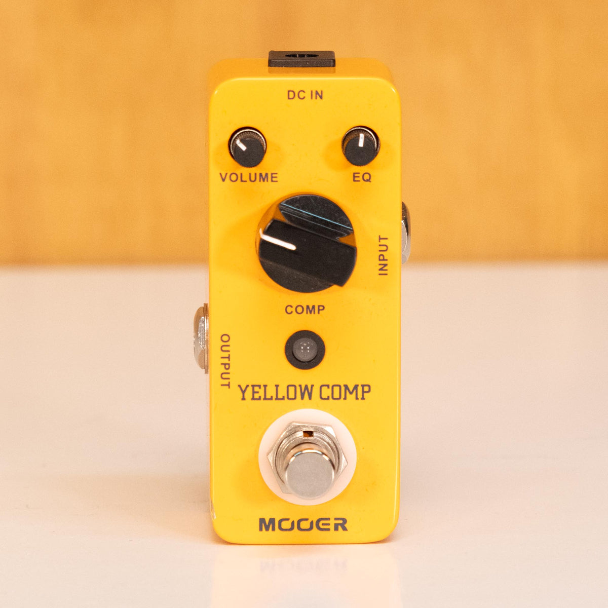 Mooer Yellow Comp optical compressor effect pedal with control knobs, compact design, and input/output jacks visible.