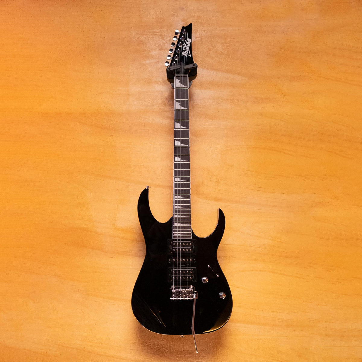 Ibanez GRG170DX electric guitar in black with a sleek body and six strings, showcasing its modern design and hardware.