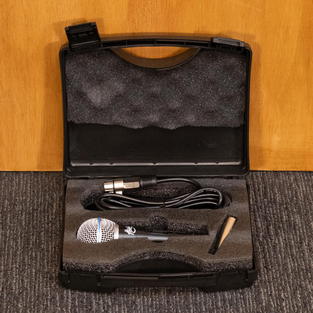 Huxley wired live microphone in protective case, ready for use, with a sleek design and professional build.